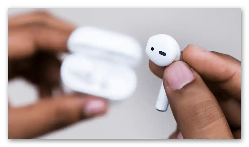Eden slušalke AirPods se uporablja, medtem ko se druga polni v etuiju