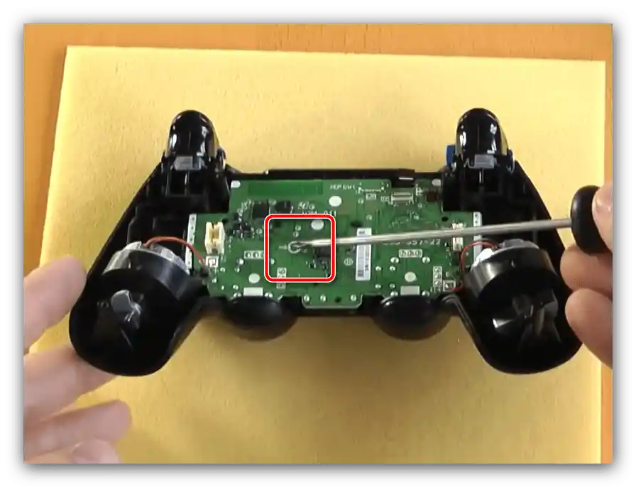 إزالة برغي تثبيت اللوحة الأم لتفكيك النسخة الأولى من ذراع التحكم PS4